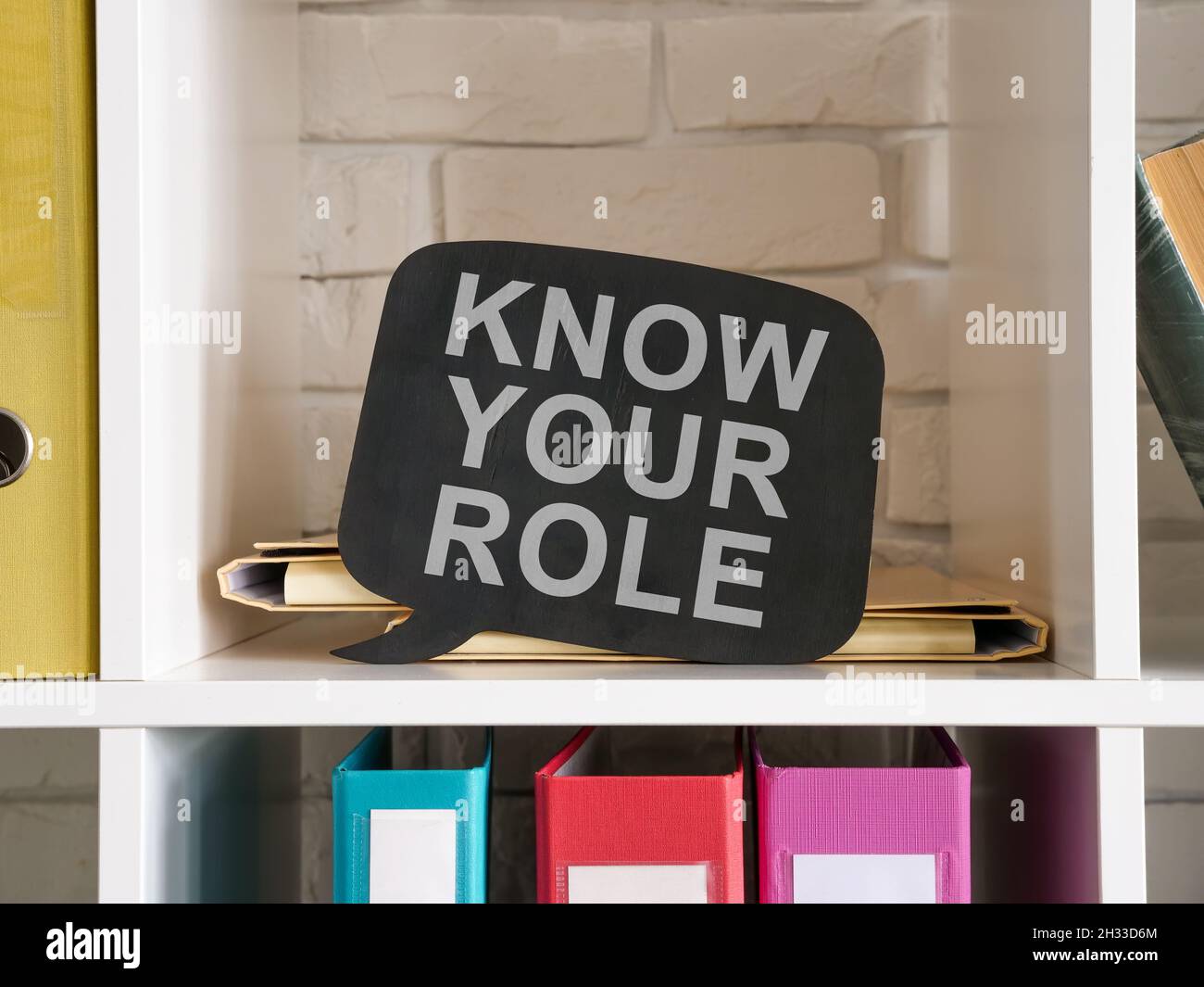 Shelves with folders and a sign know your role. Stock Photo