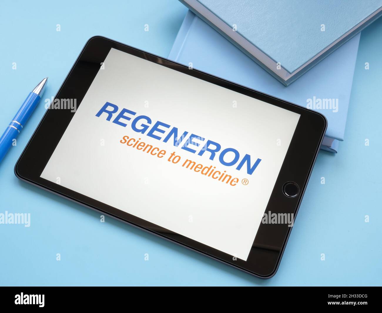 KYIV, UKRAINE - October 21, 2021. Regeneron Pharmaceuticals logo on the blue desk. Stock Photo