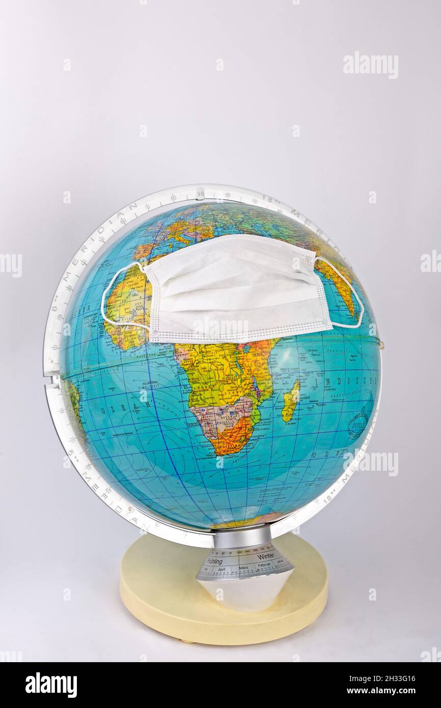 Globus mit OP Maske, Symbolbild Corona - Pandemie Stock Photo