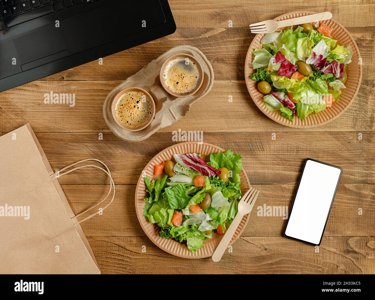 Online food delivery in disposable tableware with white blank smartphone screen. Stock Photo
