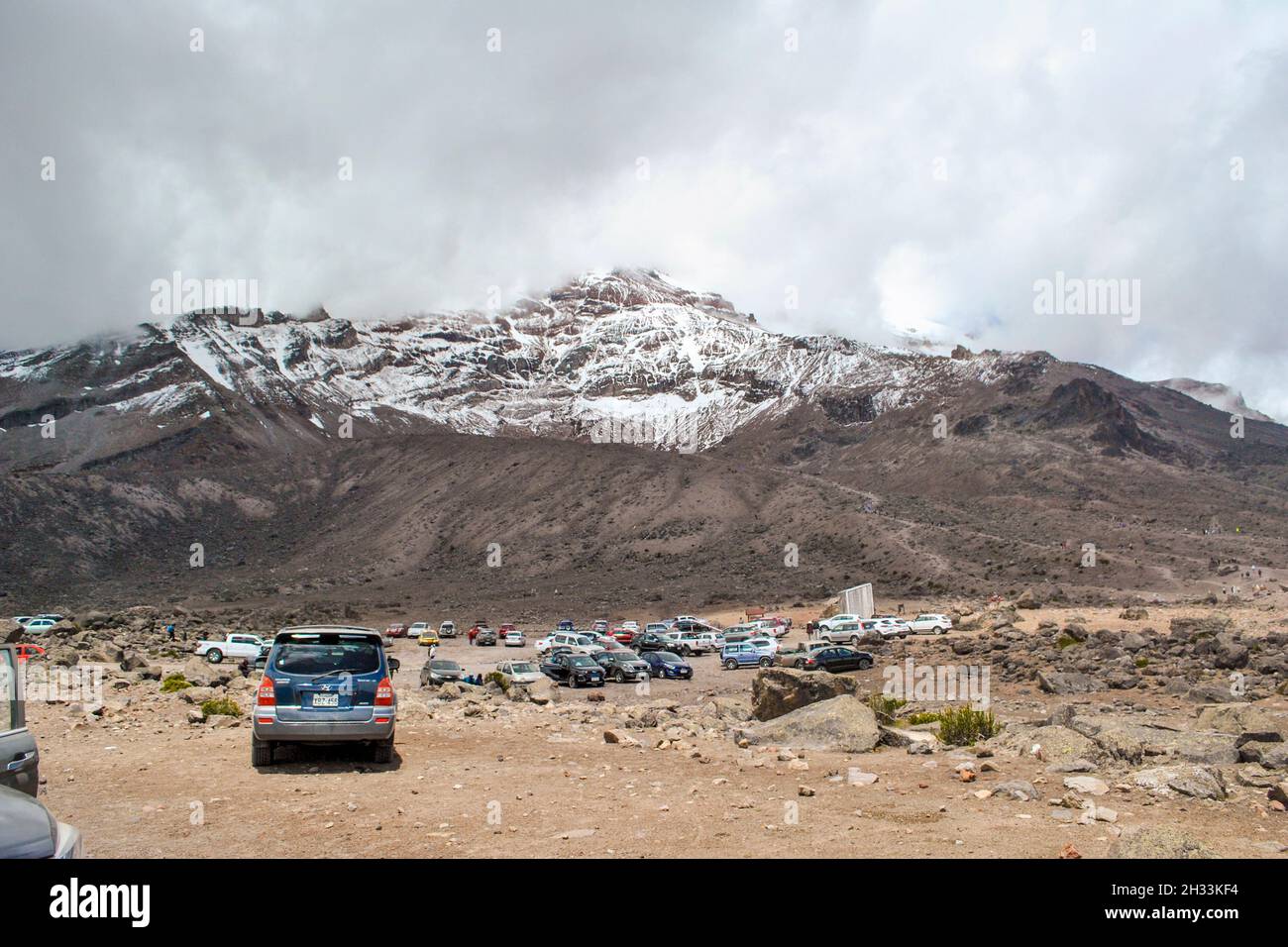 Cars parked at the foot of the Chimborazo volcano.  Riobamba, Chimborazo, Ecuador Stock Photo