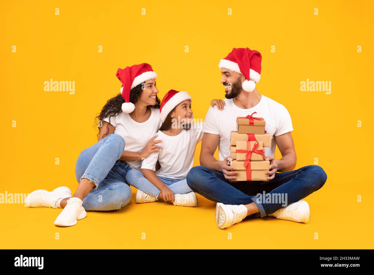 Christmas Celebration. Joyful Arab Family Of Three Wearing Santa Hats ...