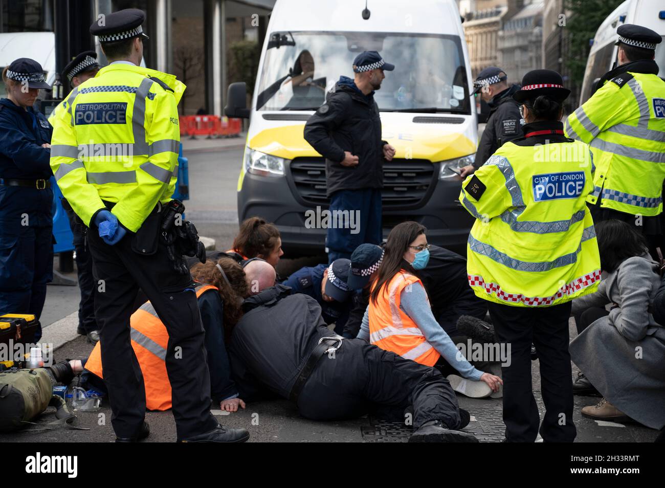 Members of Insulate Britain glued to the road at Liverpool Street, London, to protest at the need for the government to insulate housing and thus save Stock Photo