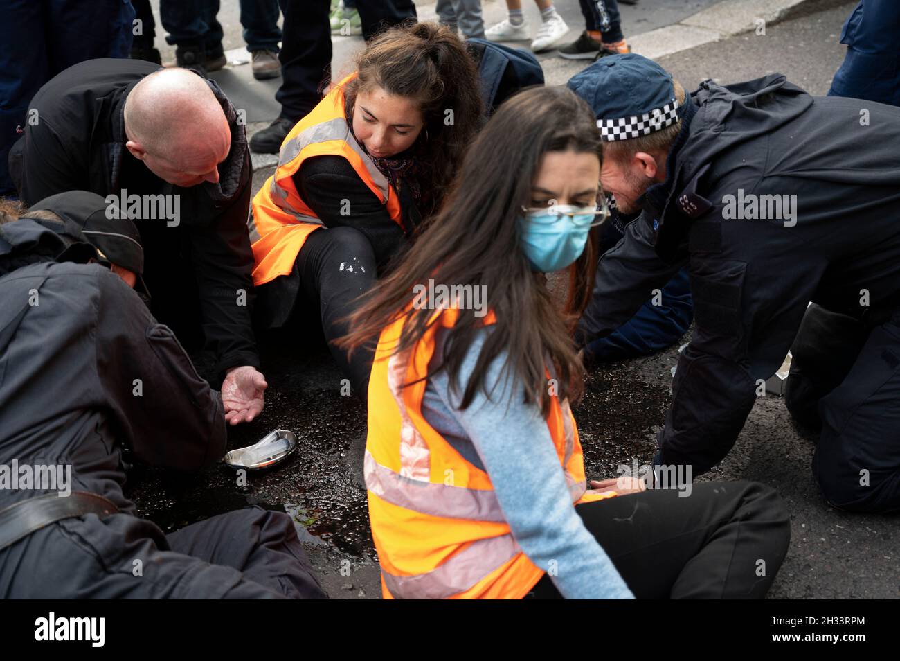 Members of Insulate Britain glued to the road at Liverpool Street, London, to protest at the need for the government to insulate housing and thus save Stock Photo