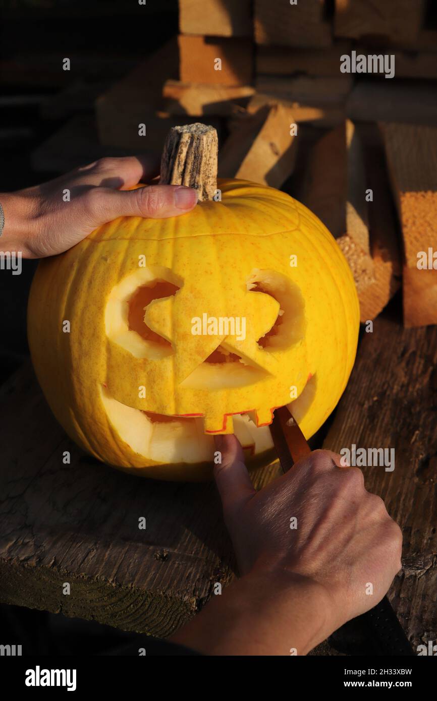 Carve a pumpkin with a knife for Halloween Stock Photo Alamy