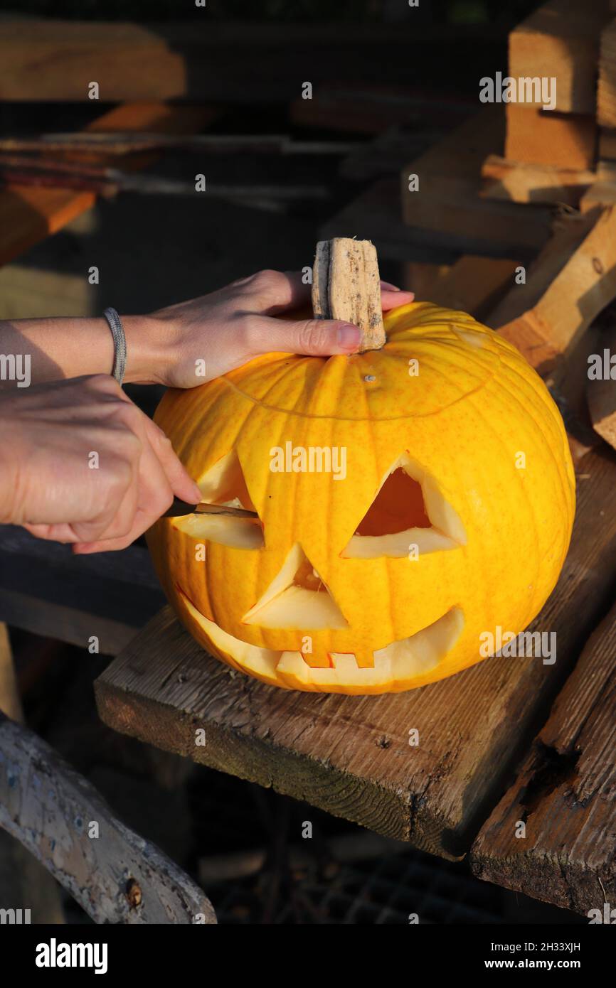 Carve a pumpkin with a knife for Halloween Stock Photo Alamy