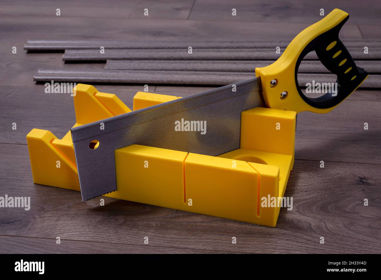 Construction tool - miter saw with miter box on a laminate floor. Stock Photo