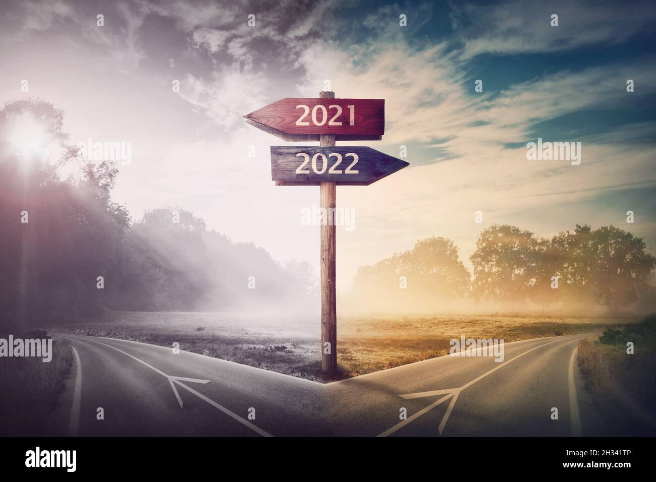 Conceptual scene choose road 2022 year or 2021. Split ways and signpost arrows showing two different courses, left and right Go ahead to the future or Stock Photo