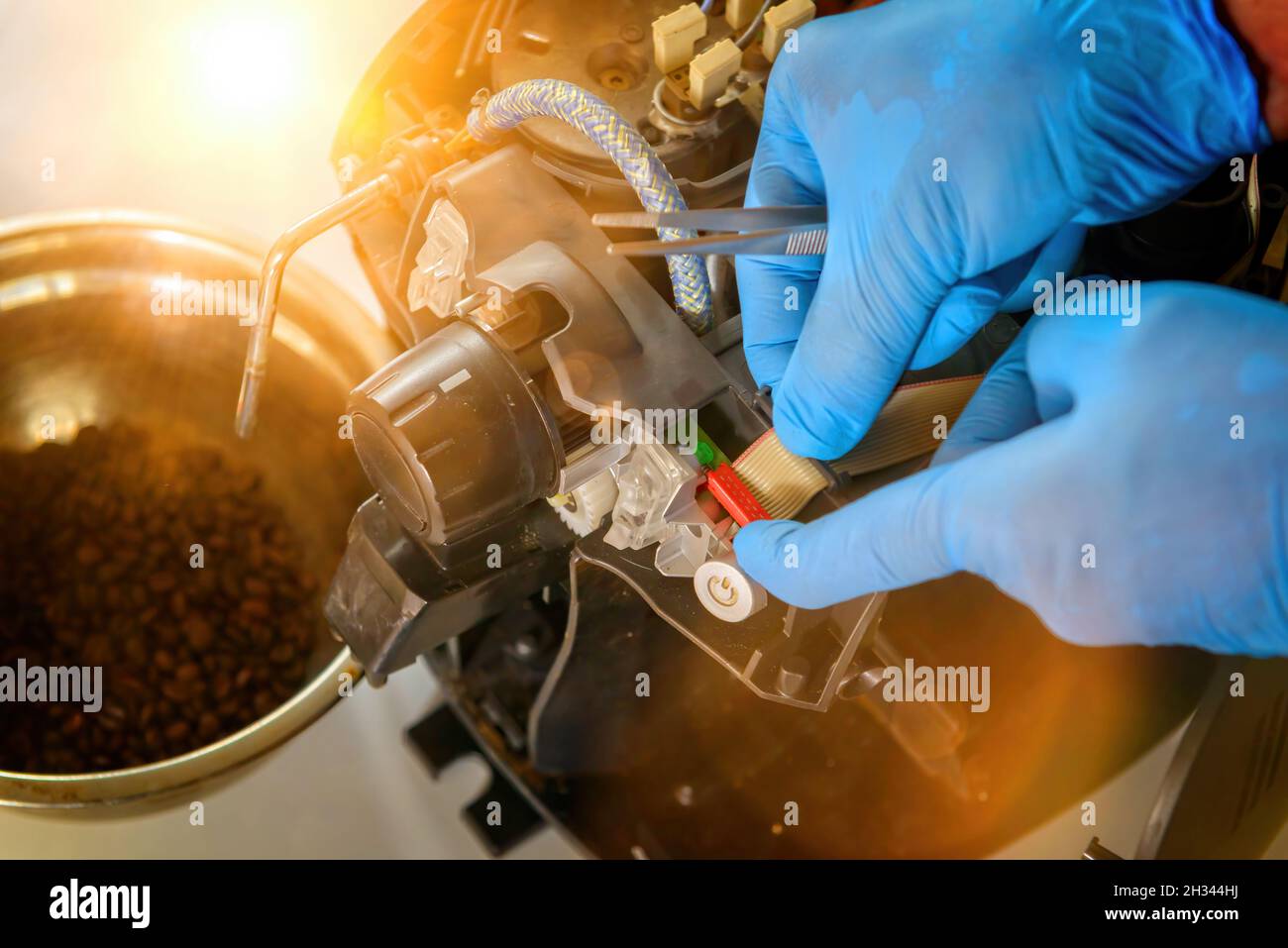 A repairman repairs a broken coffee maker with tool Stock Photo