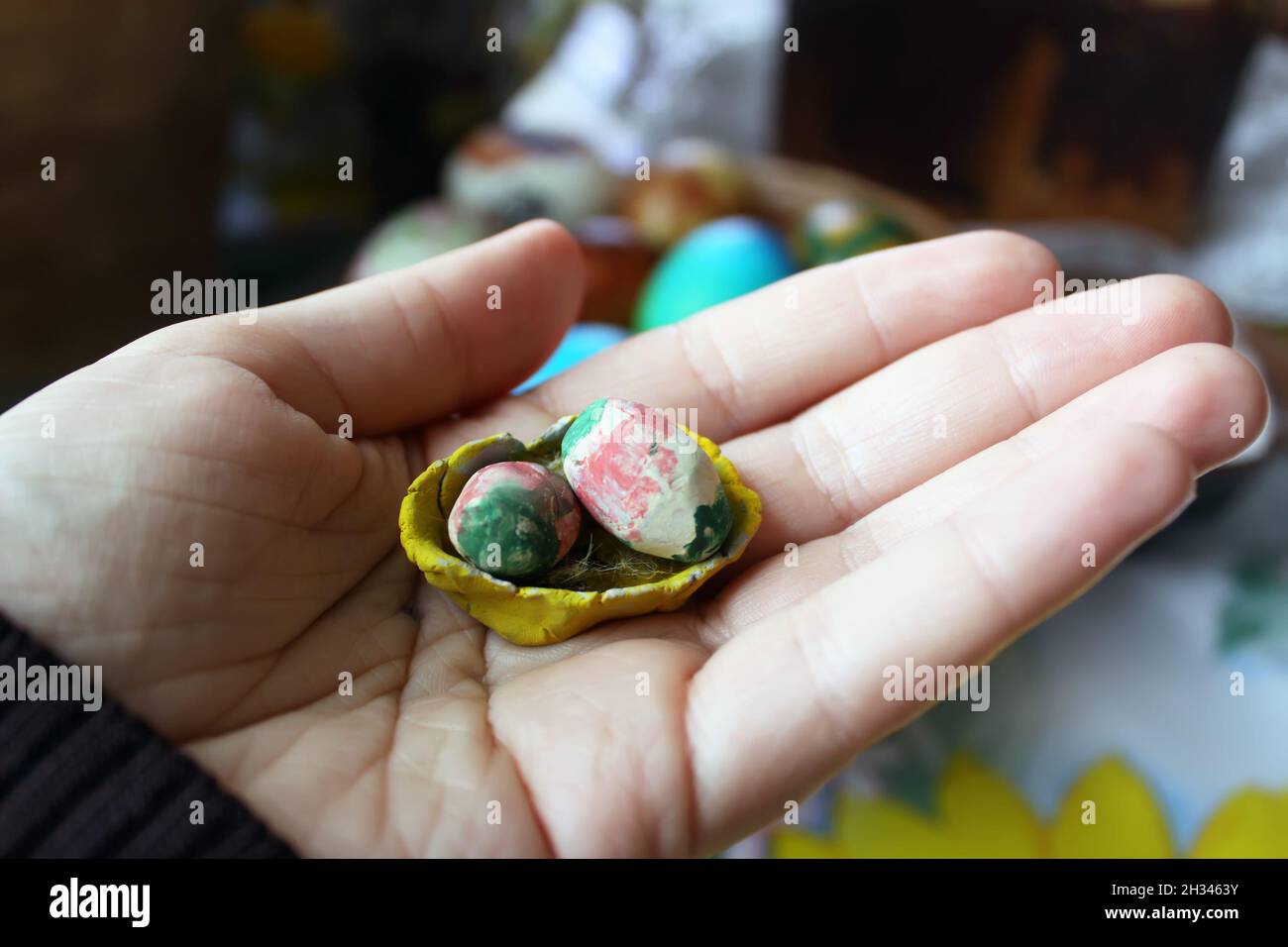 Hand holding stylized decorative handmade easter eggs. Stock Photo