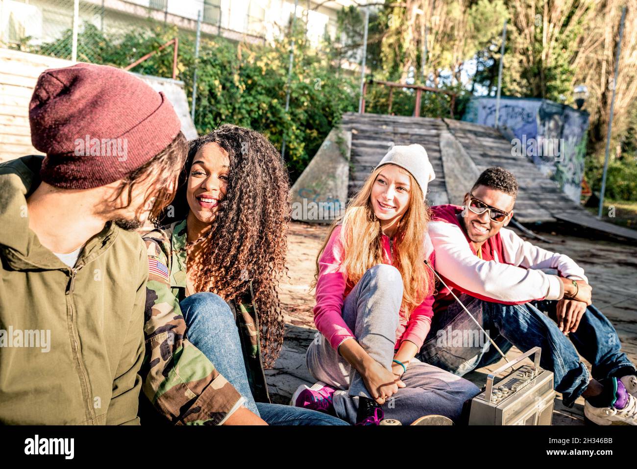 Group of urban style friends having fun time out at skate bmx park - Youth friendship concept with people together outdoors Stock Photo