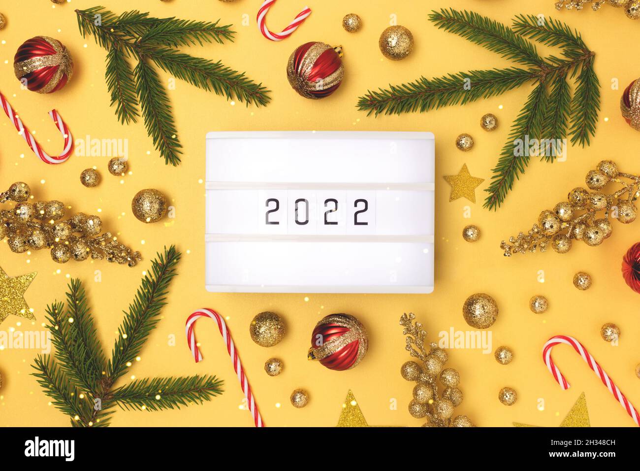 Lightbox with 2022 numbers. New Year decorations on a golden background. Stock Photo