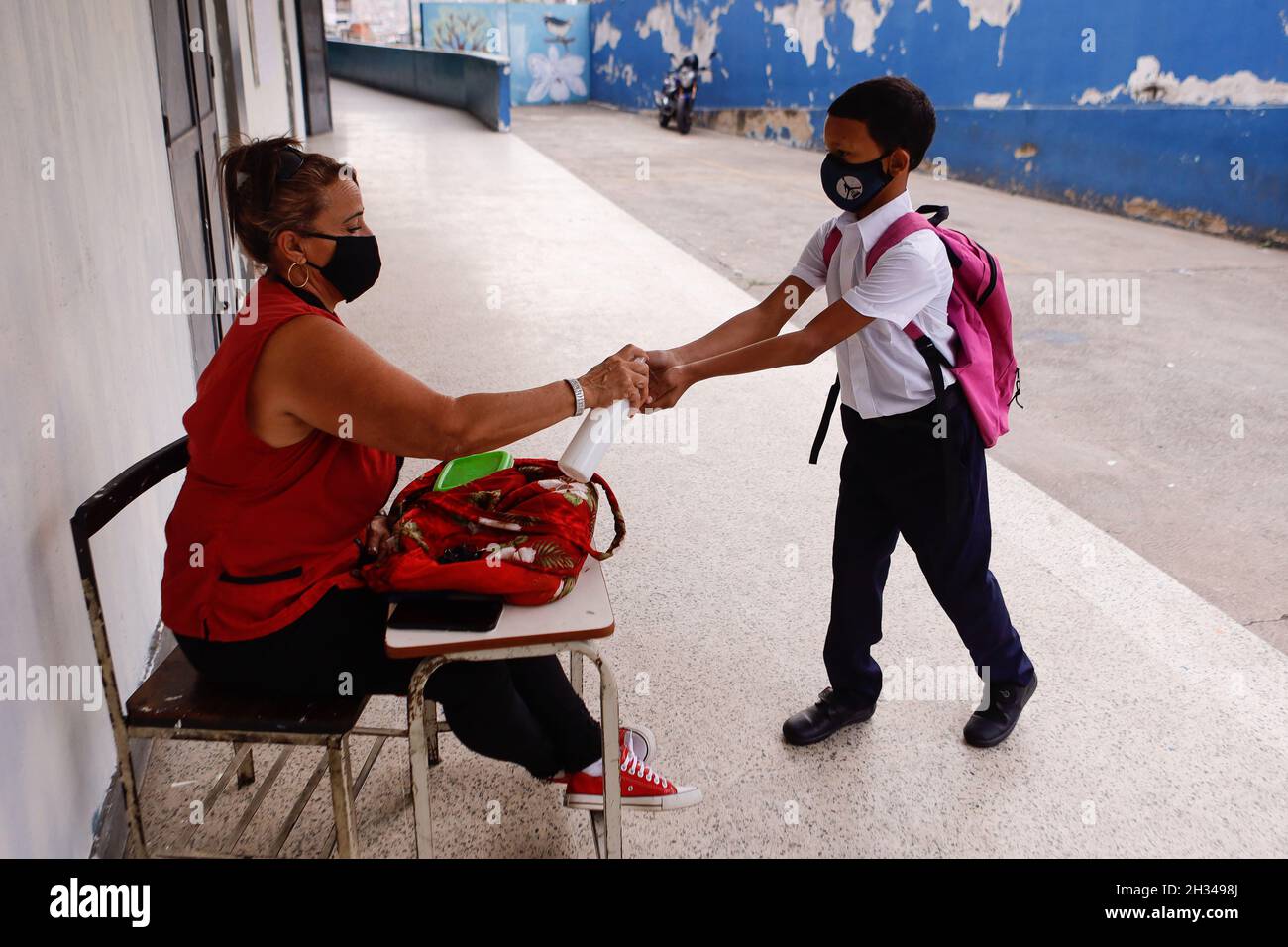 Caracas, Venezuela. 25th Oct, 2021. A boy in school uniform has alcohol