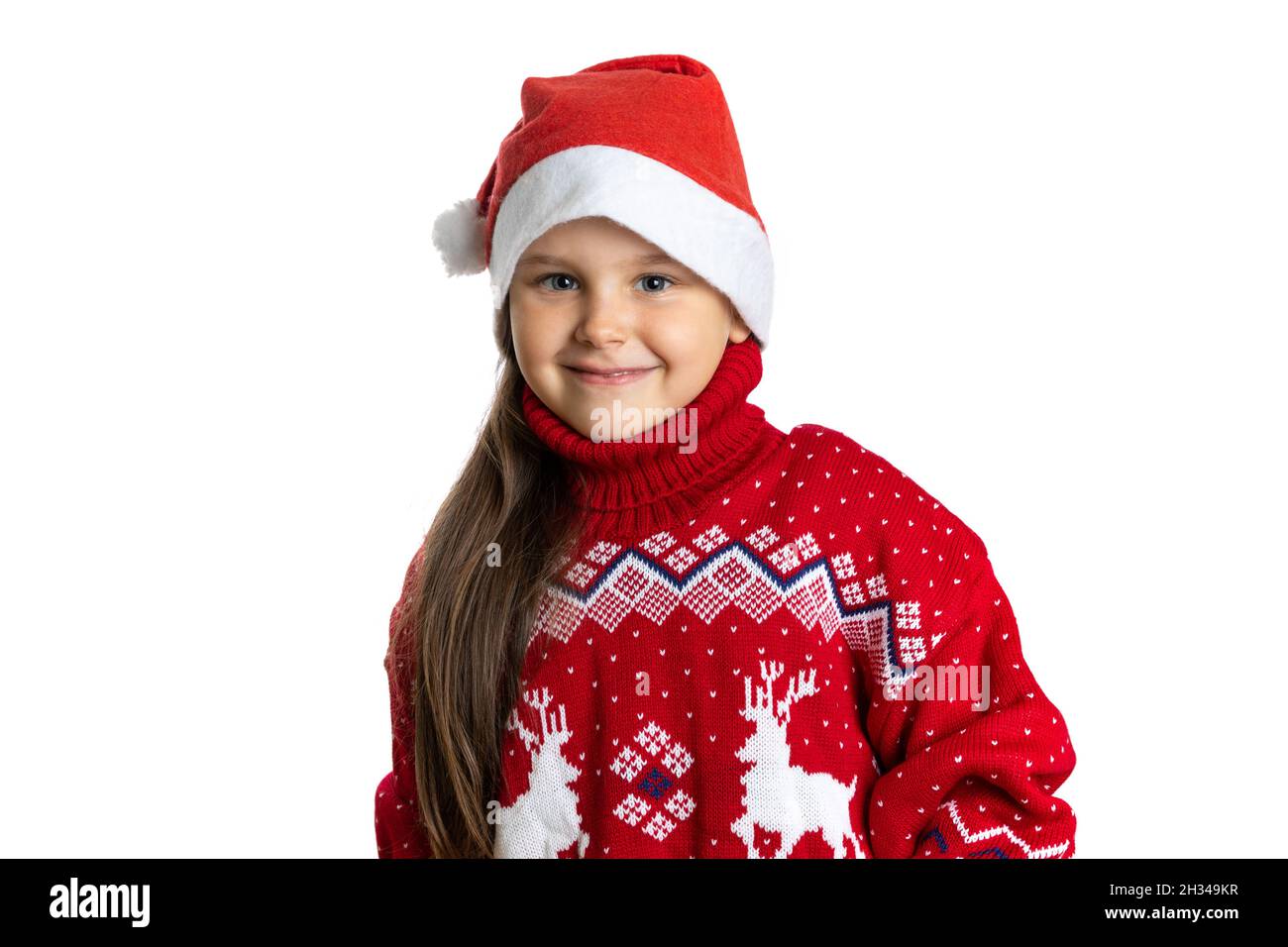 portrait of beautiful, happy girl in red Santa Claus hat in red Christmas sweater with reindeer, isolated on white background Stock Photo