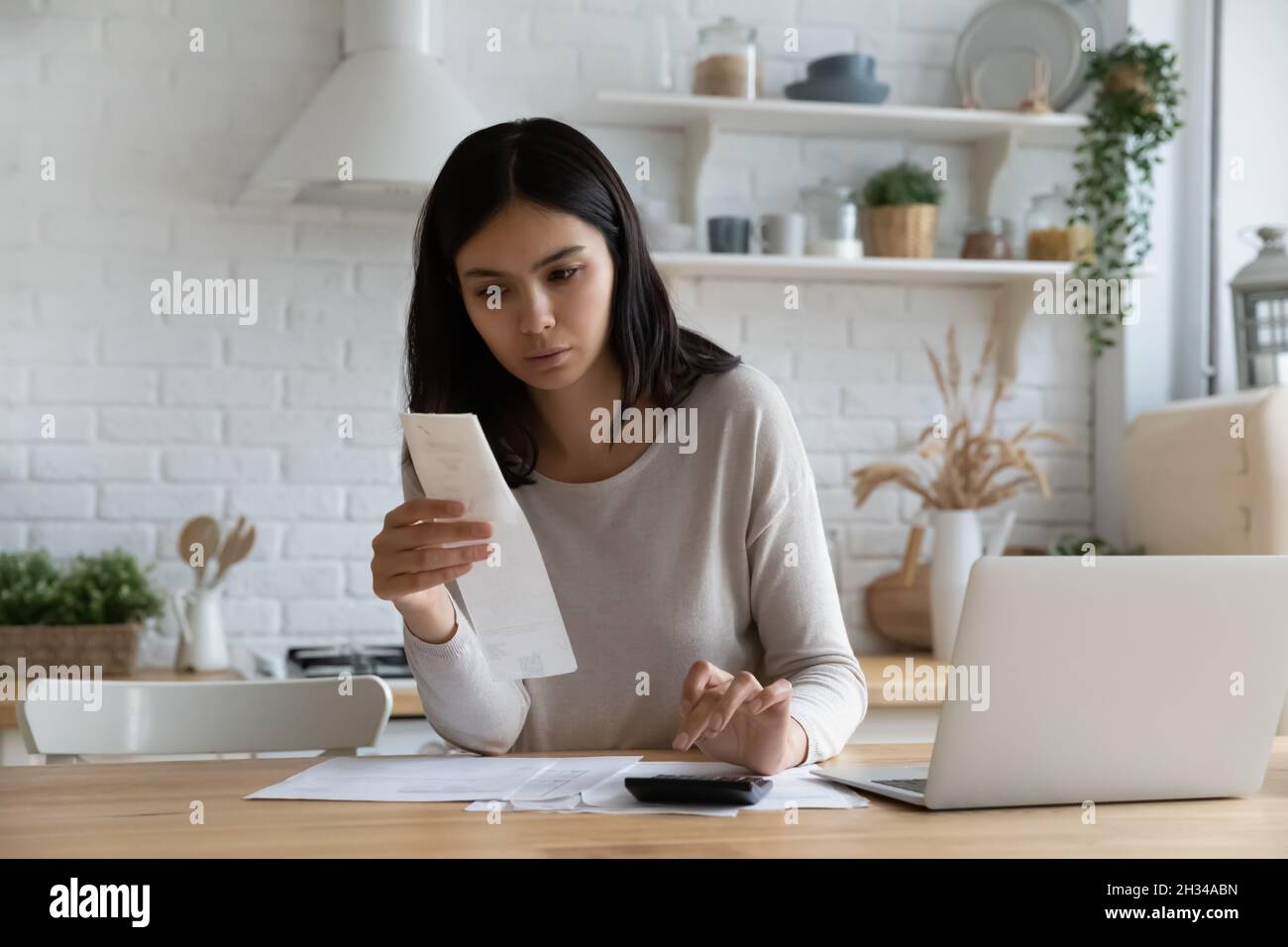 Serious young Asian woman, renter, homeowner checking Stock Photo