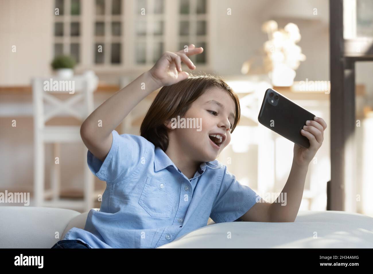 Happy excited gen Z gamer kid winning online virtual game Stock Photo