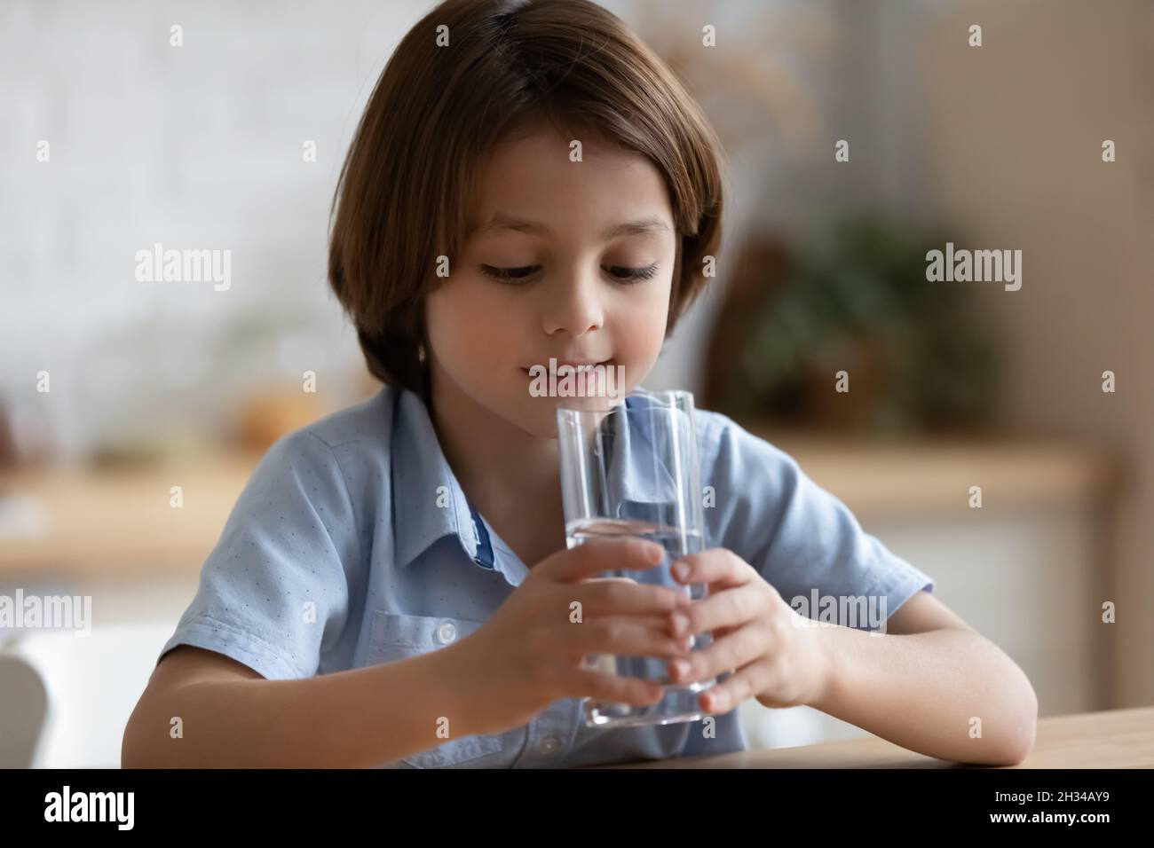 Cute thirsty kid boy drinking fresh filtered clean water Stock Photo