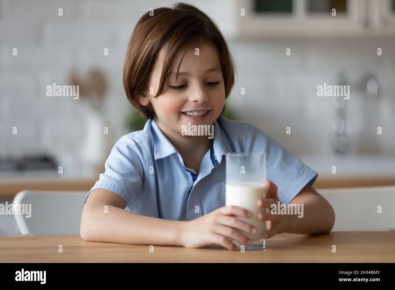 Happy boy with funny white moustache drinking milk Stock Photo