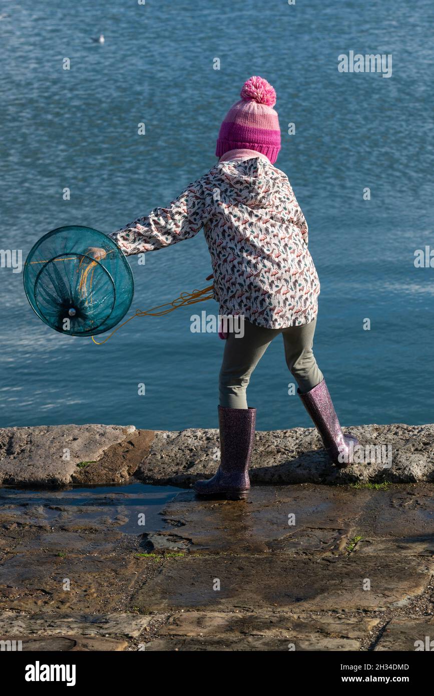 Small girl crabbing on the quay at Langstone overlooking Emsworth