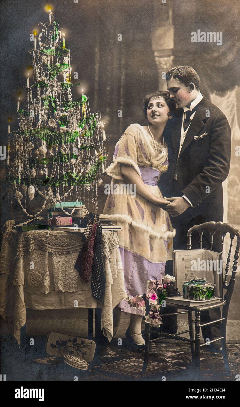 Man and woman in love celebrated with christmas tree. Vintage picture with original film grain and blur Stock Photo