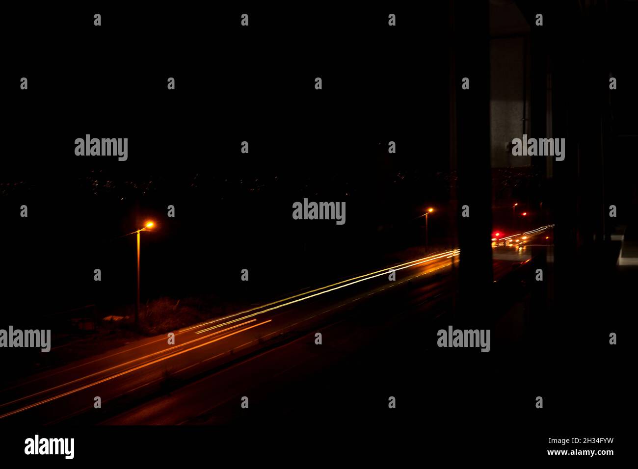 Night photo with long exposure with street lamp and cars front and rear lamps reaminings on the photo. Stock Photo