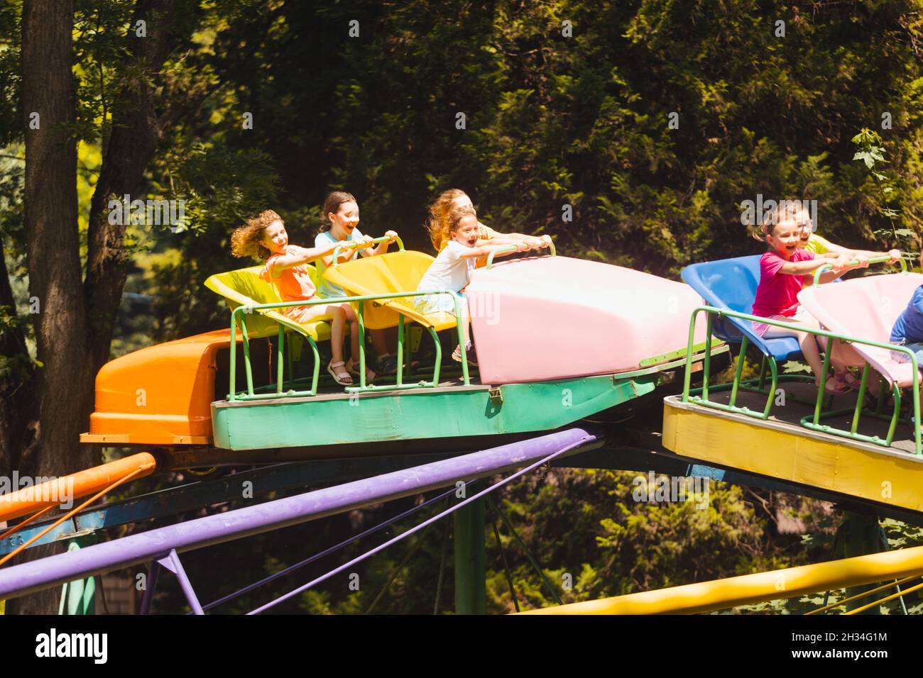 Little Kid Rides The happy kids on a roller coaster in the amusement park Stock Photo ...