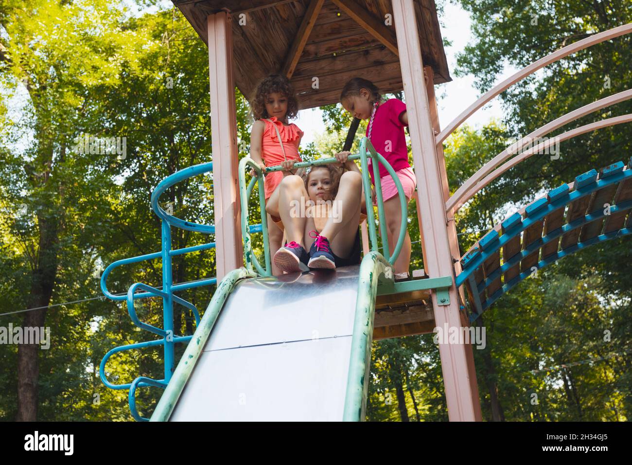 The little girl is sitting on a slide in the playground Stock Photo - Alamy