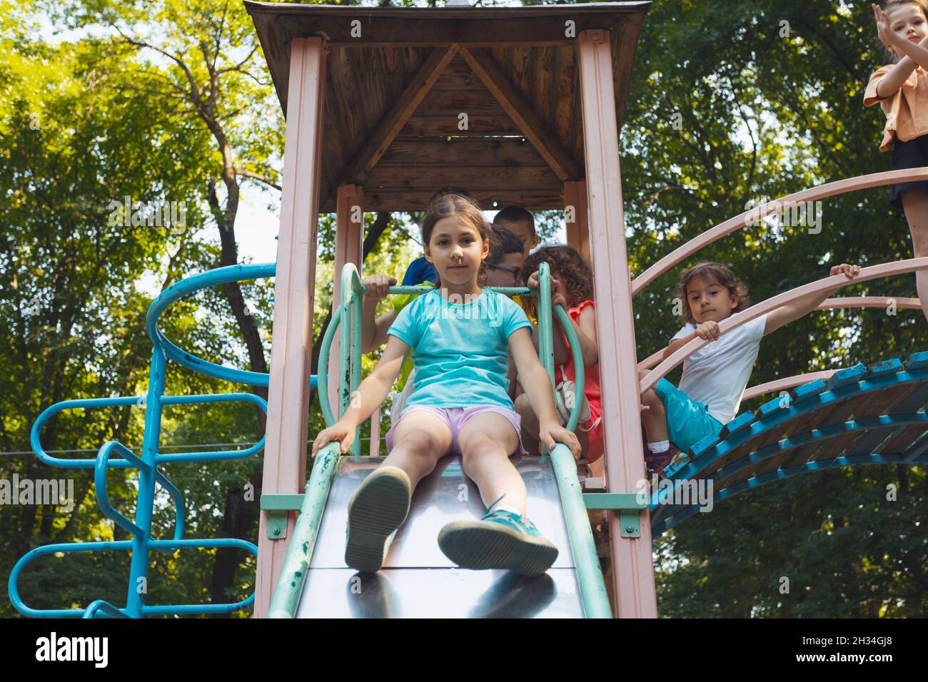 The little girl is sitting on a slide in the playground Stock Photo - Alamy
