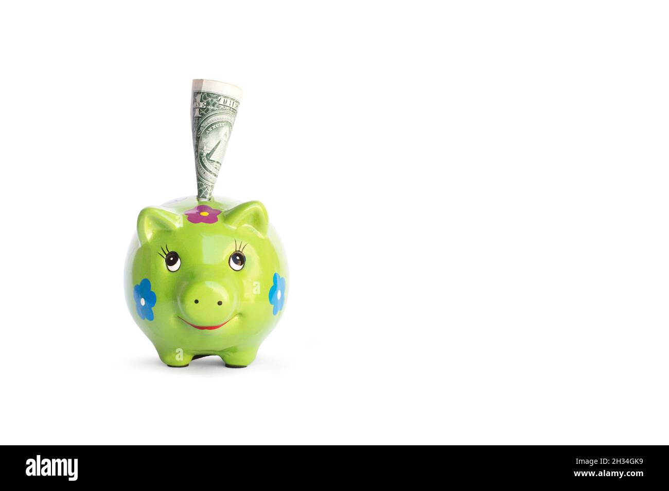 Green piggy bank and one dolar bill on a white background with copy space Stock Photo