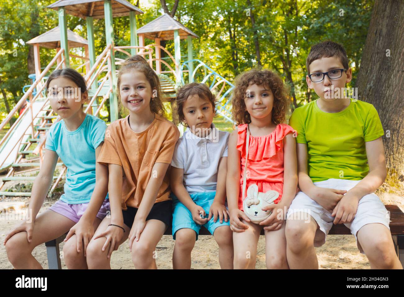 The happy kids are sitting on a bench in the park Stock Photo - Alamy