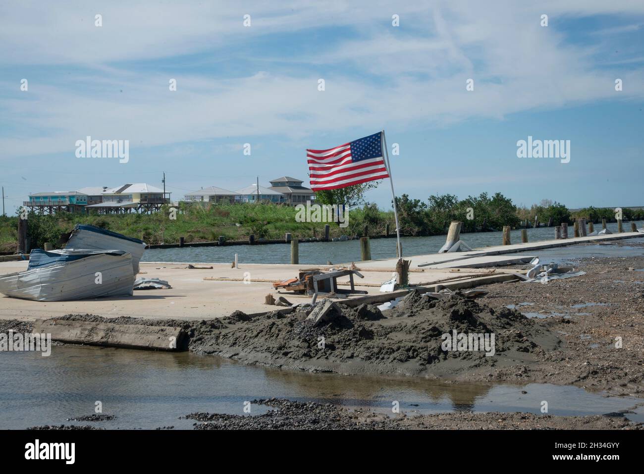 Grand Isle, United States of America. 16 October, 2021. An American flag flutters on a destroyed fishing dock in the aftermath of Hurricane Ida weeks after the devastating Category 4 storm struck the region October 16, 2021 in Grand Isle, Louisiana.  Credit: Patsy Lynch/FEMA/Alamy Live News Stock Photo