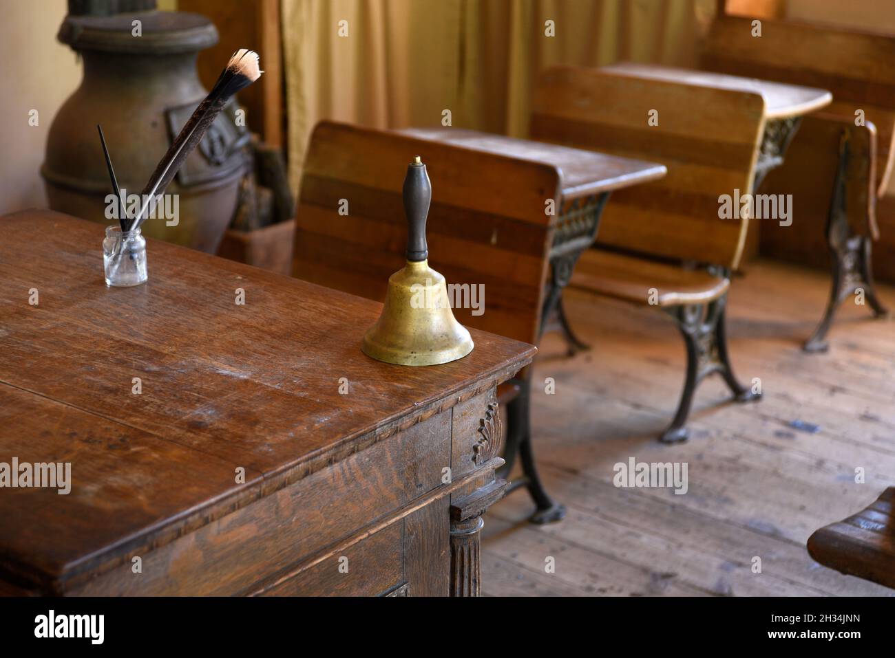 A handbell sits on the teacher's desk in a recreated 19th century school room at El Rancho de las Golondrinas living history museum in New Mexico USA. Stock Photo