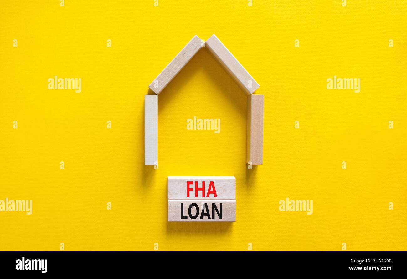 FHA federal housing administration loan symbol. Concept words 'FHA federal housing administration loan' on wooden blocks on a beautiful yellow backgro Stock Photo