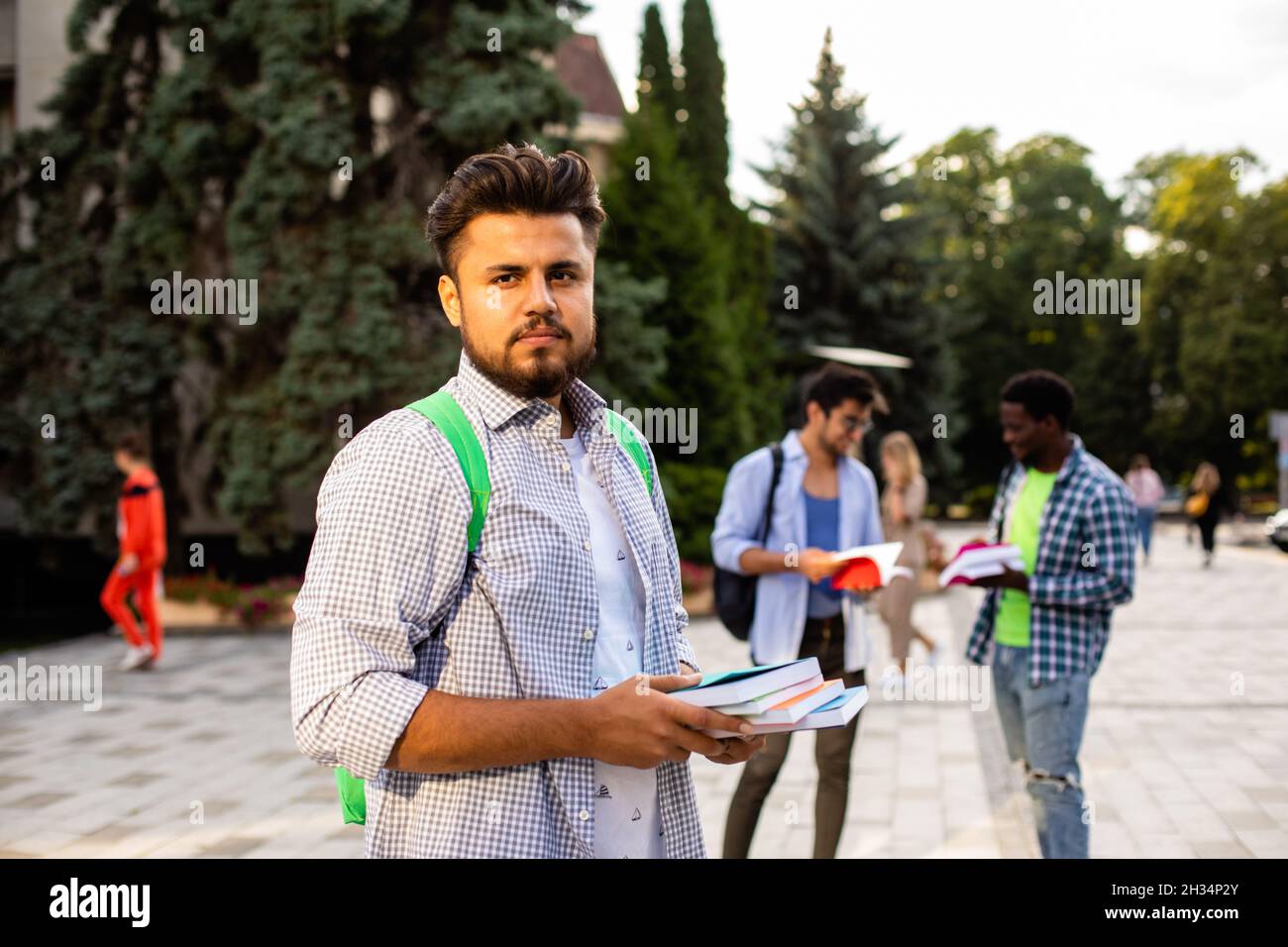 The student stands outdoors and holds a stack of books Stock Photo - Alamy