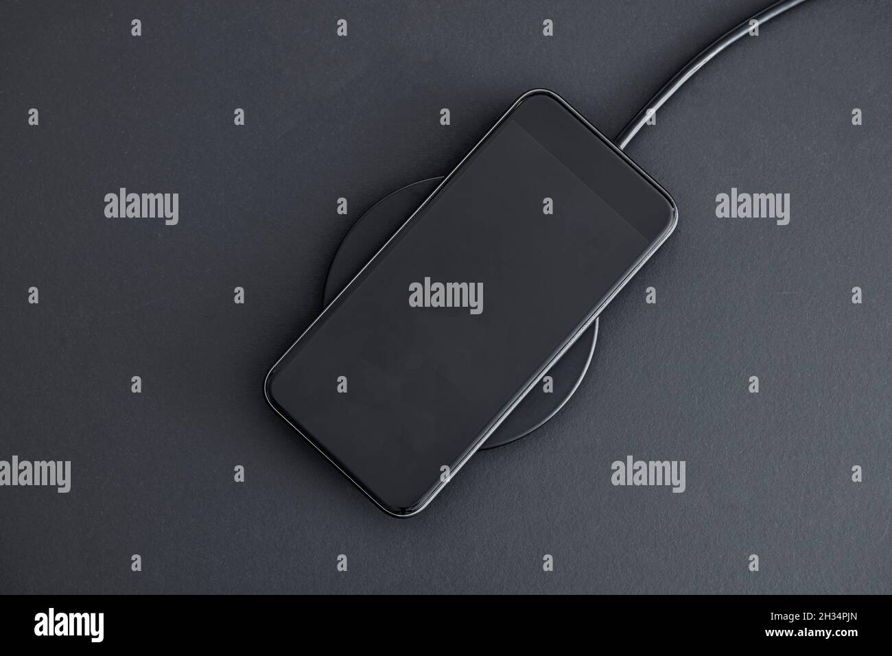 Induction wireless charging of mobile phone. High angle view of