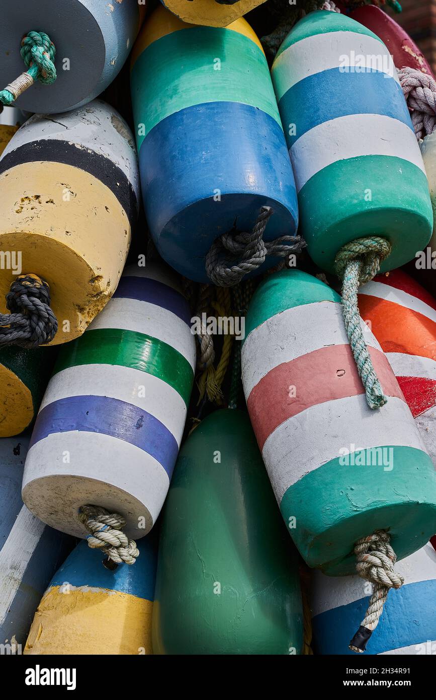 A close up photograph of a variety of different colored lobster buoys