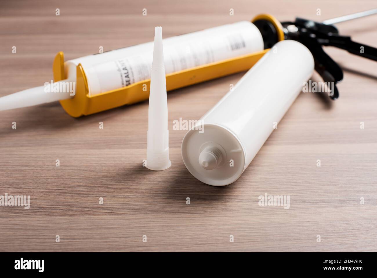 white silicone sealant cartridge and yellowblack sealant gun Stock Photo Alamy