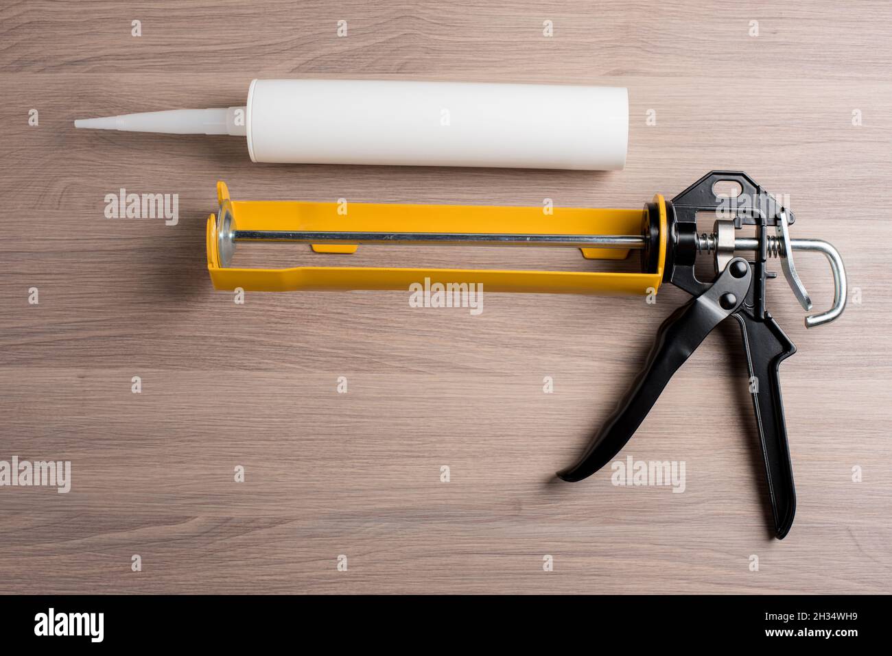 white silicone sealant cartridge and yellowblack sealant gun Stock