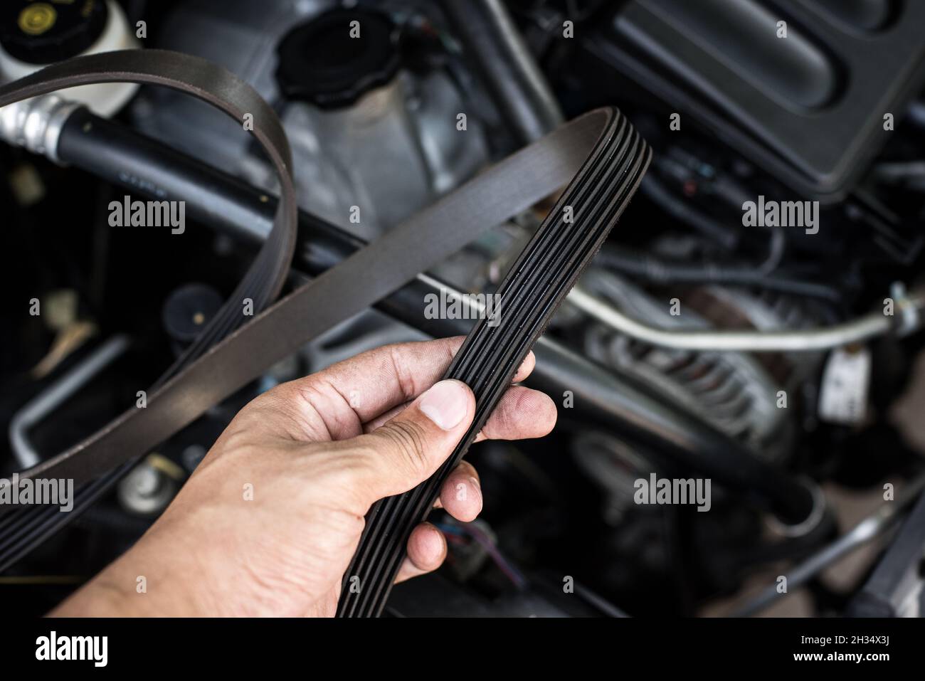 closeup old timing belt with many cracks in the engine room Stock Photo