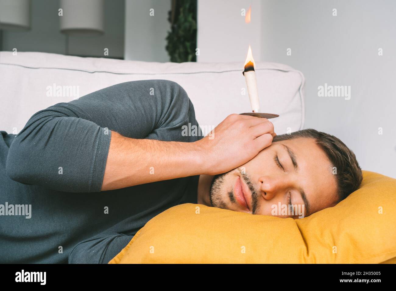 Man having ear candle treatment at home Stock Photo Alamy