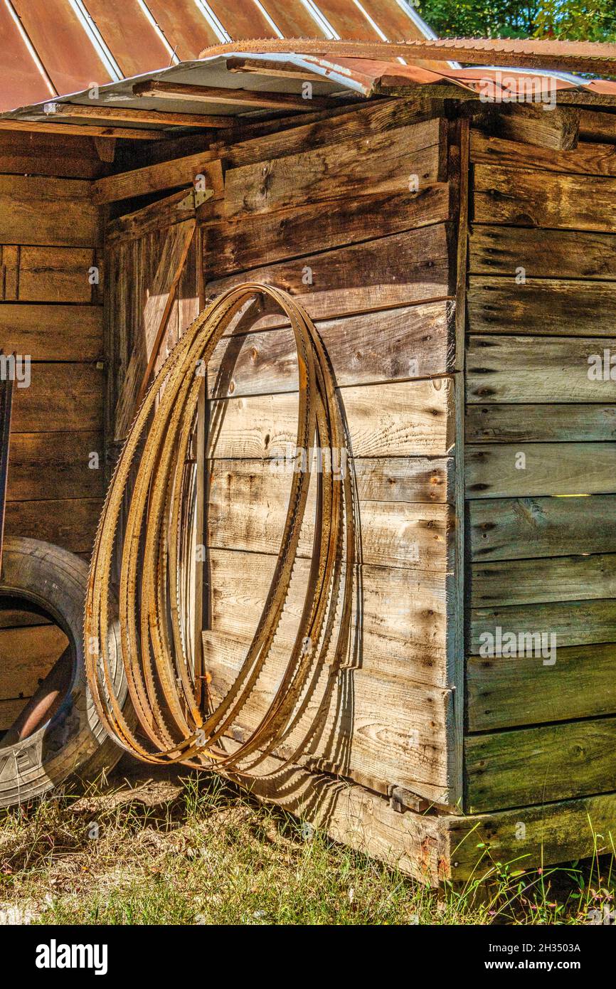 Bandsaw blades lean on a shed at an outdoor sawmill in North