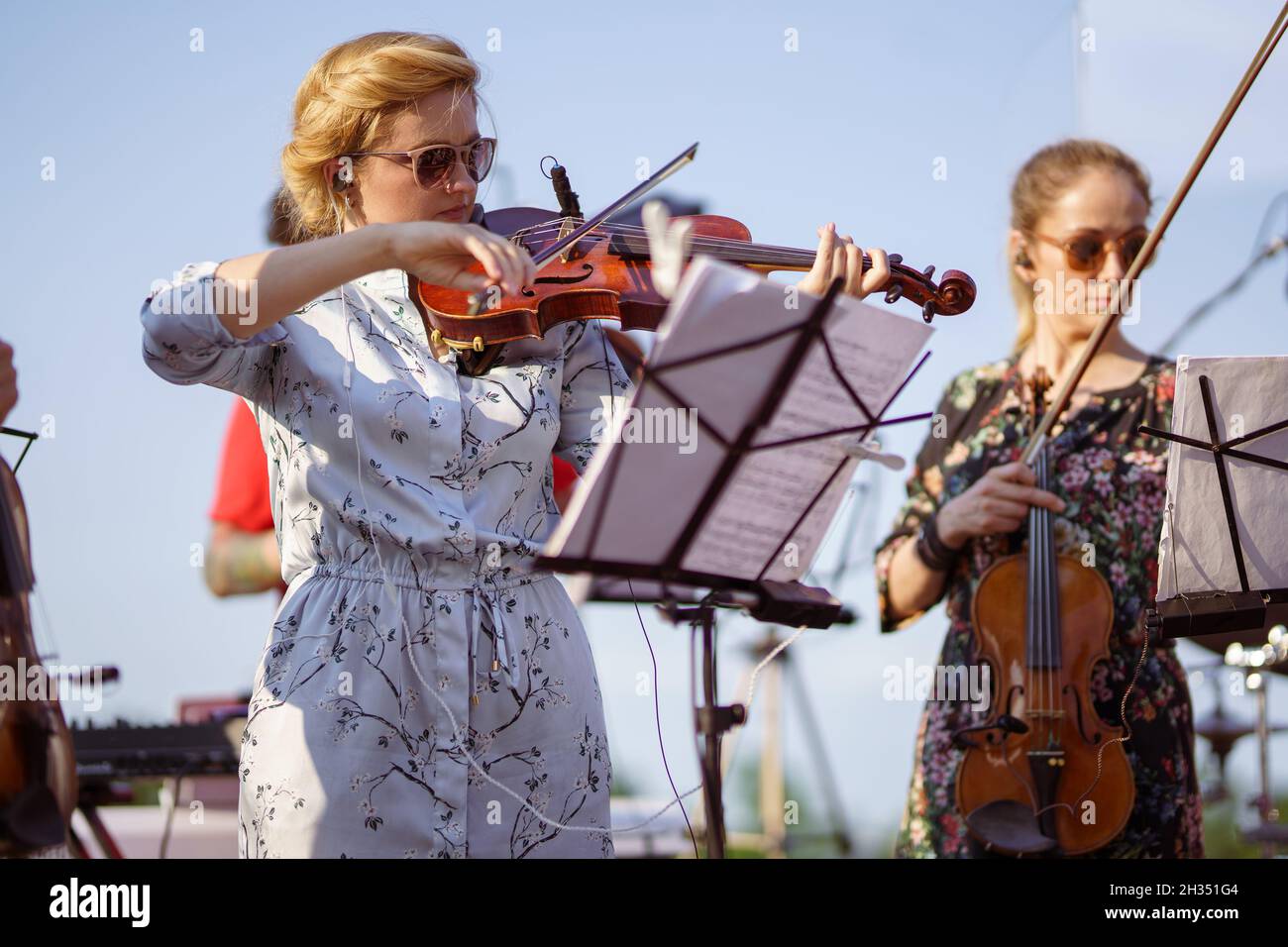 Charming woman playing violin in orchestra at outdoor concert Stock ...