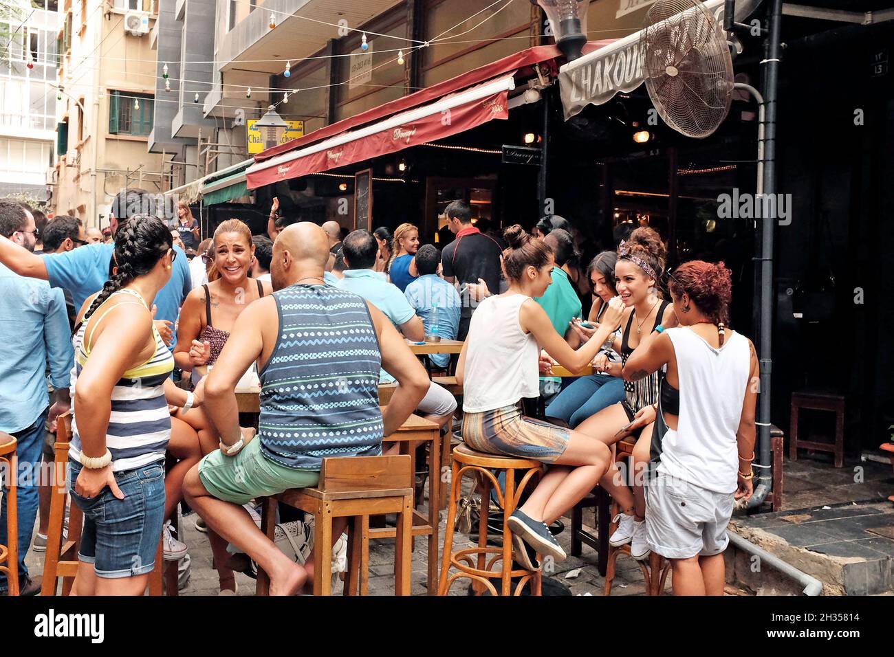 An outdoor street party scene in the bustling Hamra neighborhood of Beirut, Lebanon.  The area is filled with bars and restaurants catering to locals, expats, and students at major universities in the area. Stock Photo