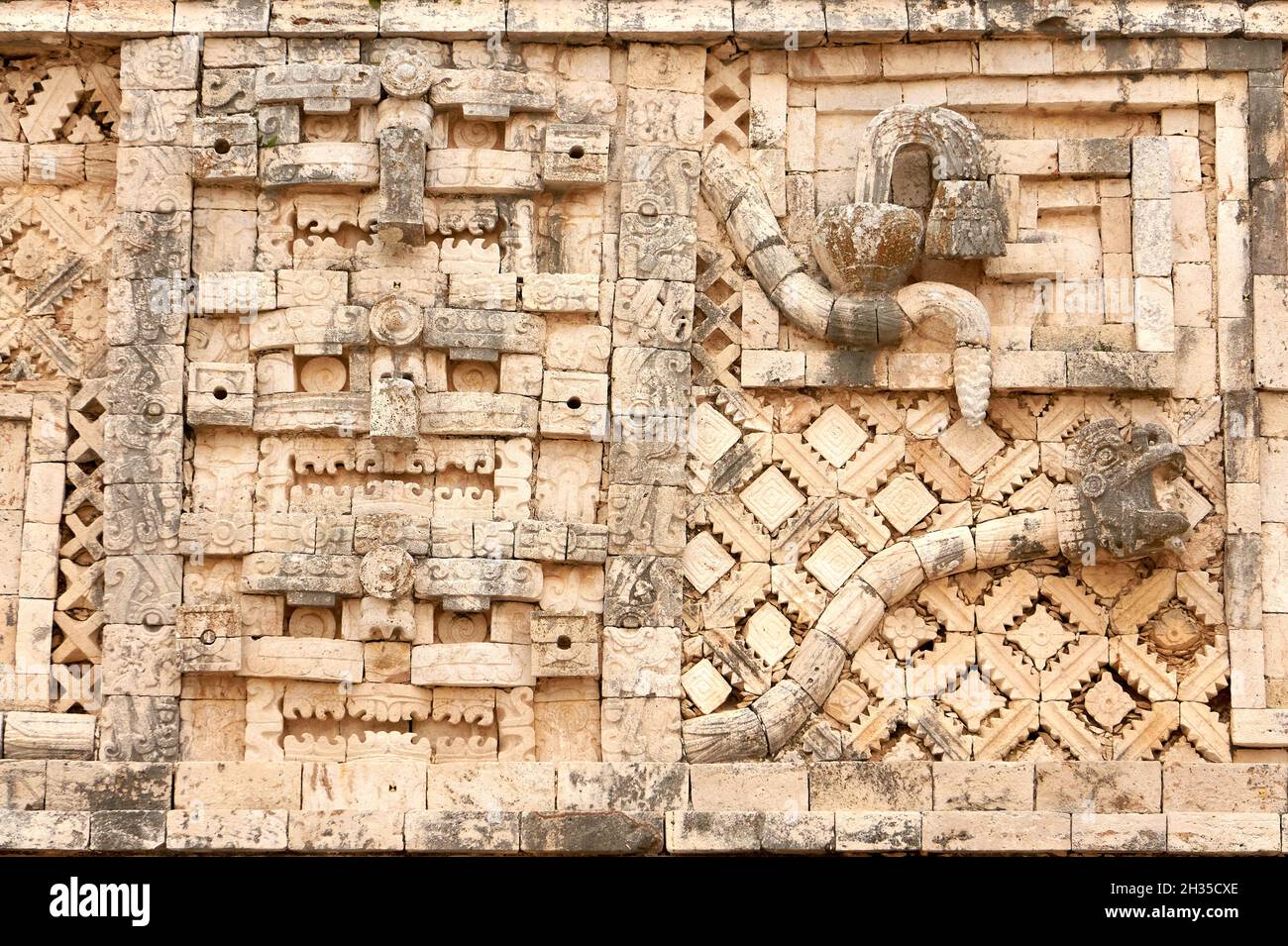 Carved stone bas-relief of Chaac masks and serpent,  Nunnery Quadrangle, Uxmal, Yucatan, Mexico Stock Photo