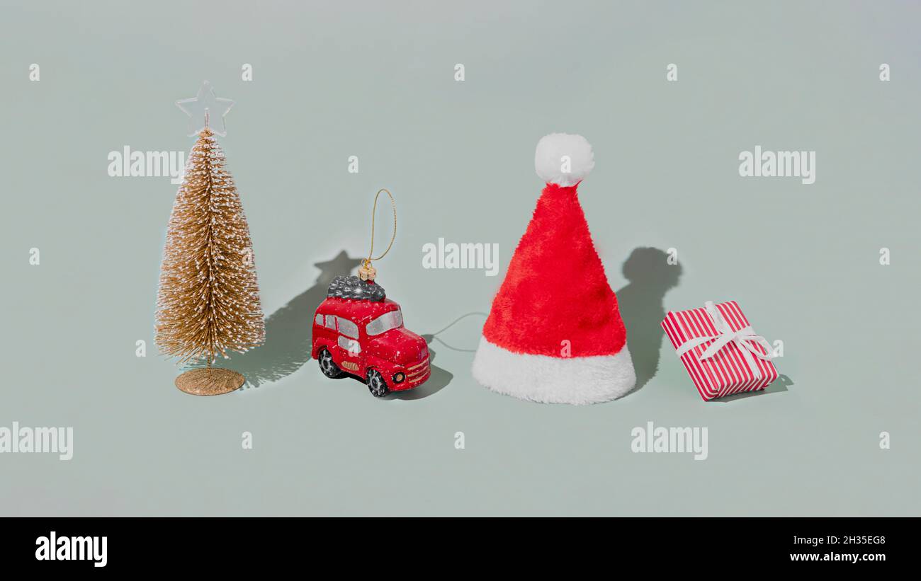 Gray background with Christmas or New Year symbol attribute objects and symbolic items concept. Pink gift box present with ribbon, small red taxi car Stock Photo