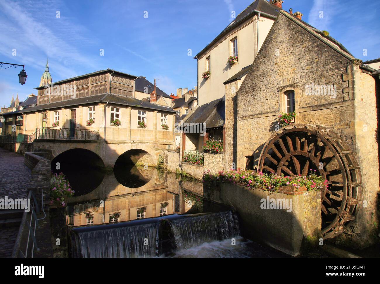 Bayeux Mill with water wheel and reflections in the River Aure and cathedral soon after sunrise in Bayeux, Normandy, France Stock Photo