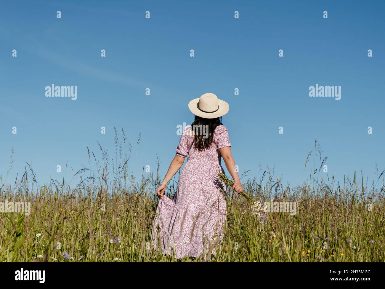Woman walking in field flowers hi-res stock photography and images - Alamy