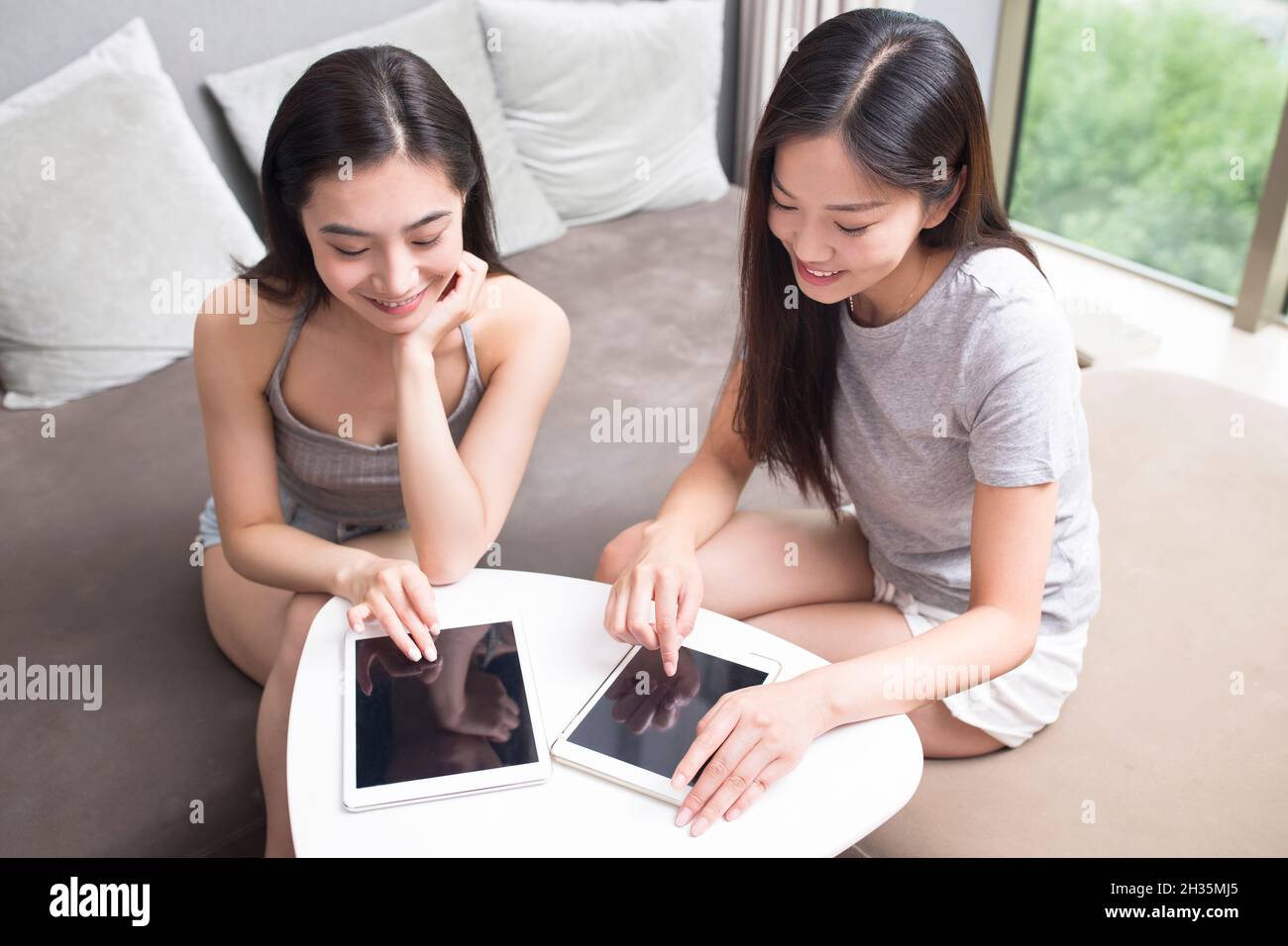 Two best friends using a laptop computer together Stock Photo