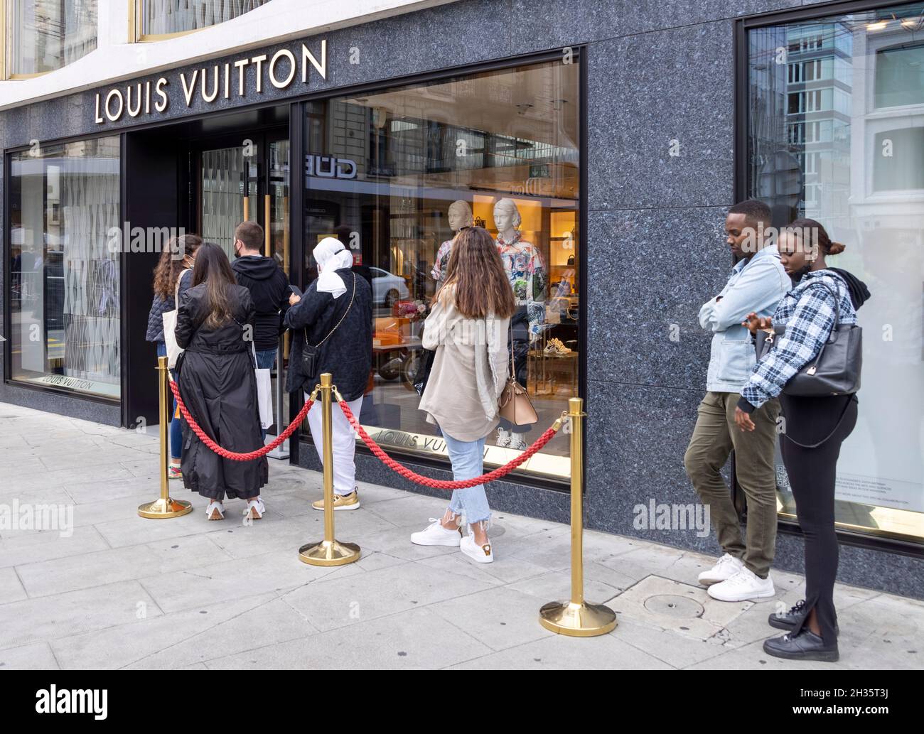 customers queuing outside Louis Vuitton shop, Geneva, Switzerland Stock Photo