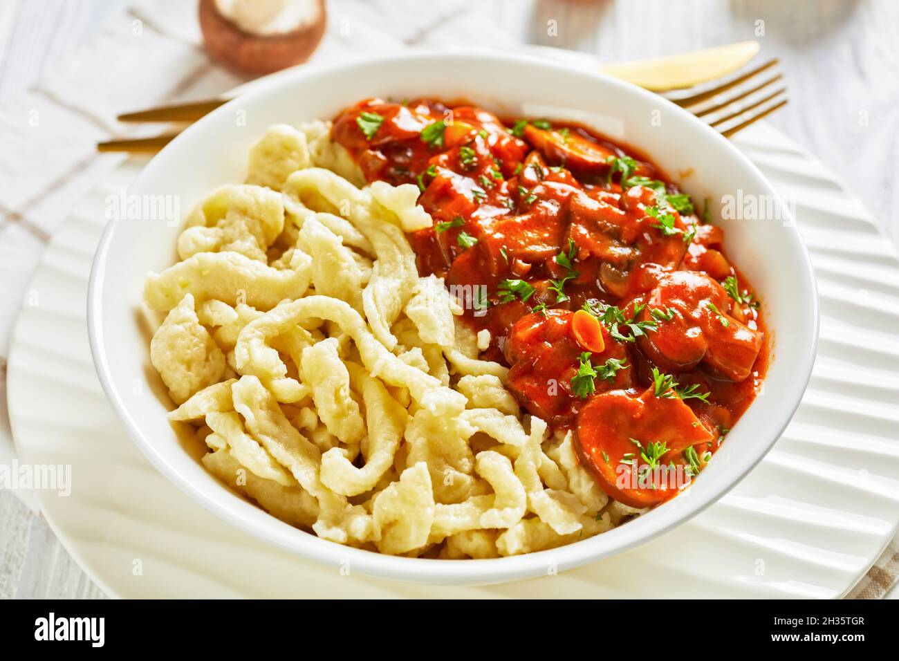 authentic german spaetzle with mushroom gravy in a white bowl